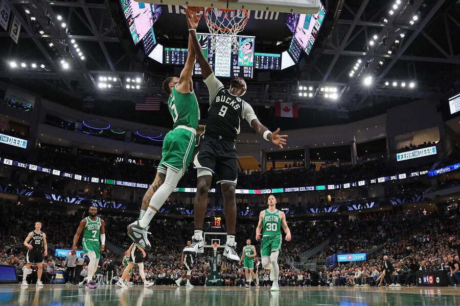 Jayson Tatum (Boston, v zelenom) a Bobby Portis (Milwaukee, v tmavom)