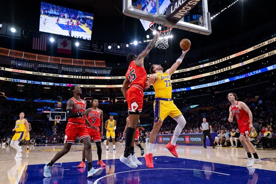 Luka Doncic pod&nbsp;košom v&nbsp;obkolesení hráčov Chicaga Bulls