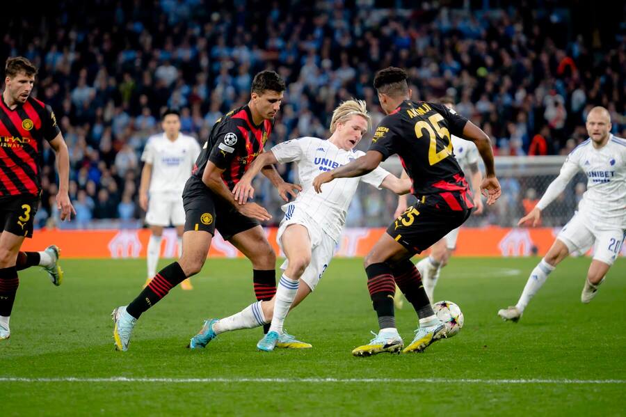 Momentka zo zápasu Kodane s ManCity; Victora Kristiansena (v bielom) zdvojujú hráči City Manuel Akanji (25) a Rodri