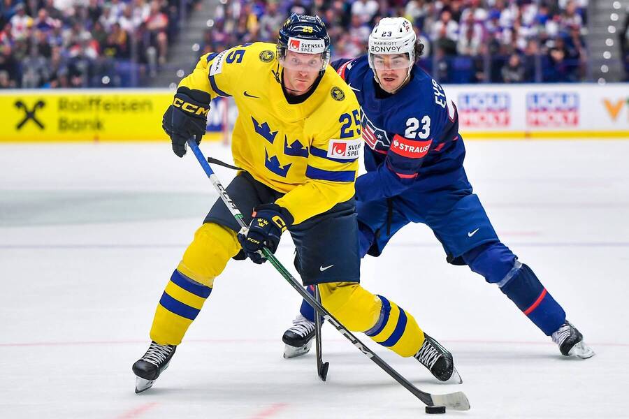 Švédsky obranca Jonas Brodin (vpredu) prenasledovaný americkým krídelníkom Michaelom Eyssimontom v zápase Švédsko vs. USA na MS v hokeji 2024