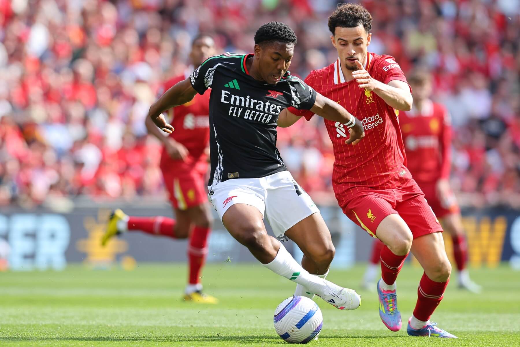 Curtis Jones (Liverpool, v červenom) a Myles Lewis-Skelly (Arsenal, v tmavom)