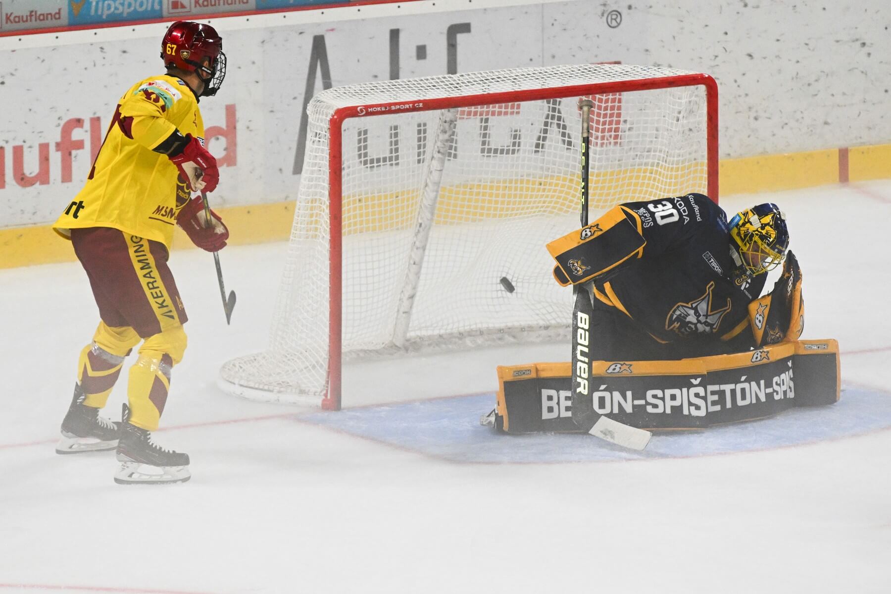 Zľava trenčiansky útočník Tomáš Záborský a brankár Spišiakov Denis Godla, ktorý inkasuje gól počas zápasu HK Dukla Trenčín vs. HK Spišská Nová Ves v 1. kole extraligovej sezóny 2024/25