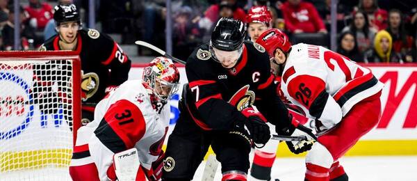 Kapitán Ottawy Brady Tkachuk sa snaží dotlačiť puk za chrbát brankára Frederika Andersena z Caroliny