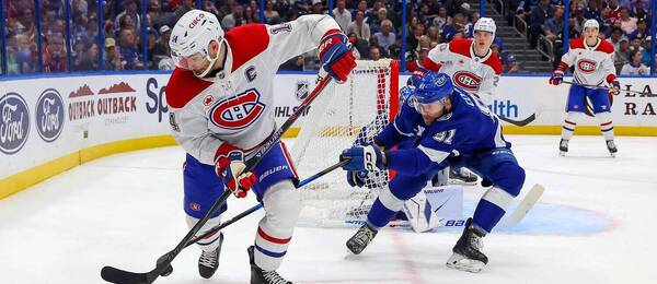 Erik Černák (v modrom) naháňa kapitána Montrealu Suzukiho, pred bránou Juraj Slafkovský