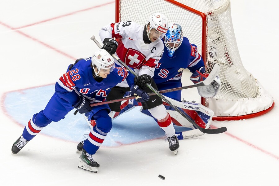 Švajčiarsky útočník Christoph Bertschy (uprostred) pred&nbsp;bránkou USA v&nbsp;zápase USA vs. Švajčiarsko v&nbsp;základnej B-skupine na&nbsp;MS v&nbsp;hokeji 2025