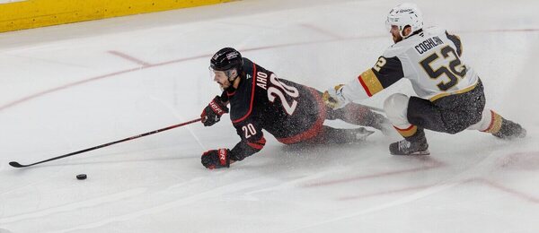 Sebastian Aho v ľahu bráni puk pred Coghlanom.