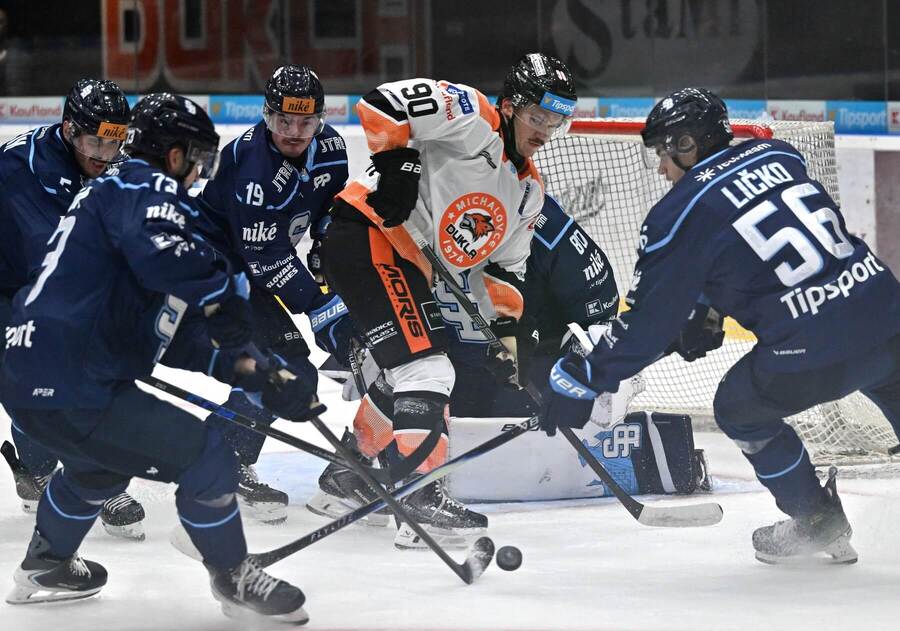 Matt Boucher v&nbsp;drese HK Dukla Michalovce v&nbsp;obkľúčení protihráčov zo&nbsp;Slovanu Bratislava.