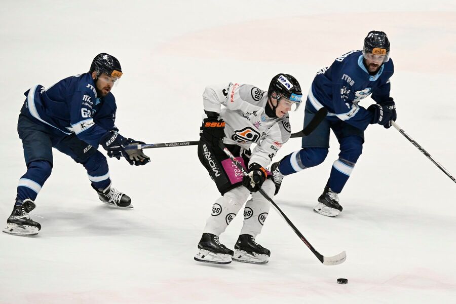 Útočník HC Košice Michal Liščinský v&nbsp;súboji s&nbsp;hráčmi HC Slovana Bratislava.